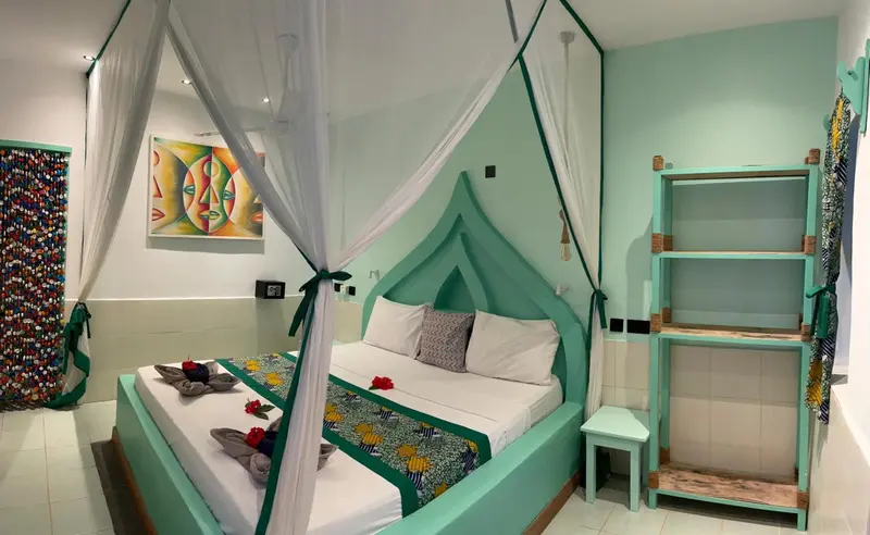 Une chambre lumineuse avec un lit à baldaquin et une décoration colorée.
