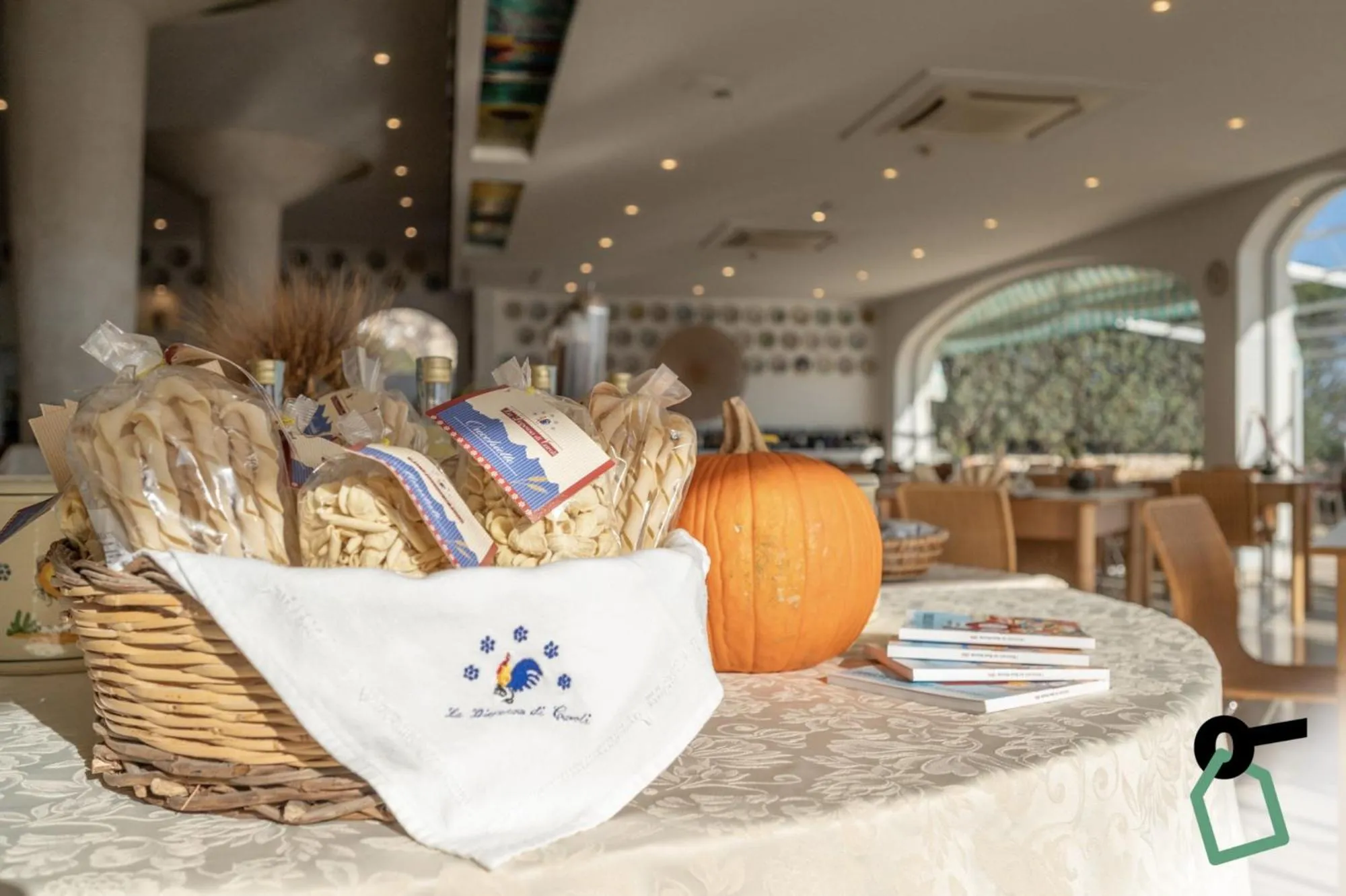 Des paniers garnis et une citrouille décorative sont disposés sur une table recouverte d'une nappe.
