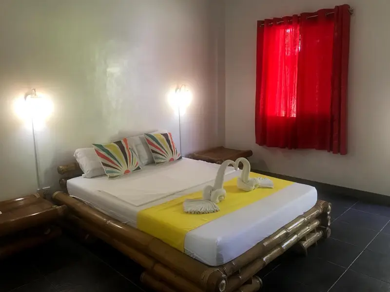 Une chambre lumineuse avec un lit décoré de serviettes en forme de cygnes.
