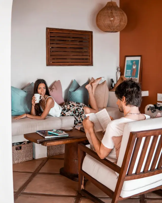 Un couple se détend dans un espace de vie lumineux et décoré avec goût.