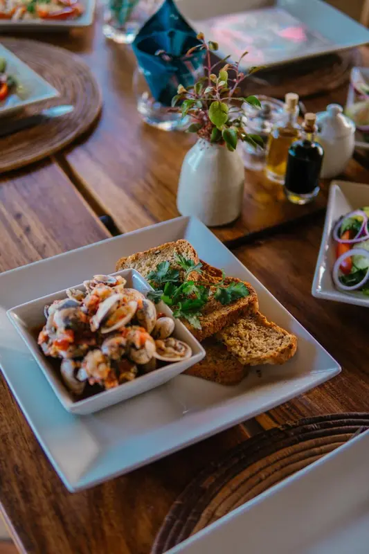 Une table est dressée avec des plats de fruits de mer et des couverts.