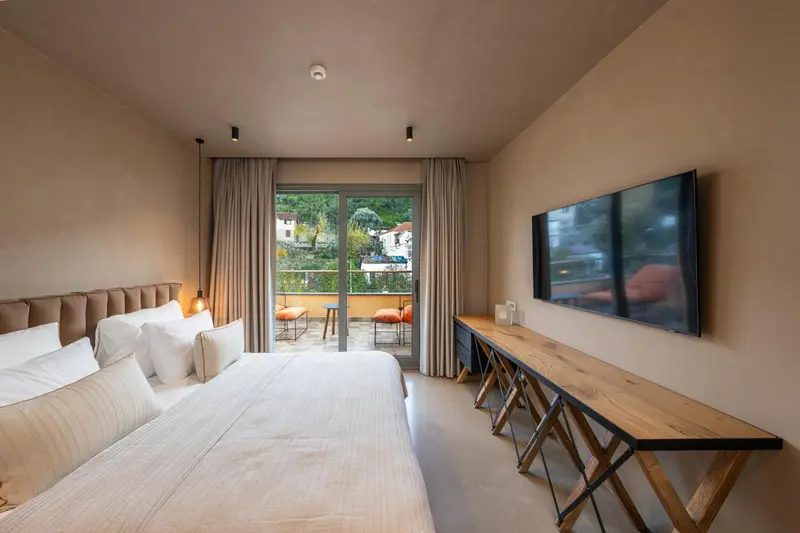 Une chambre lumineuse avec un grand lit et un bureau en bois.