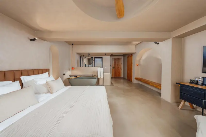 Une chambre spacieuse avec un grand lit et une baignoire.