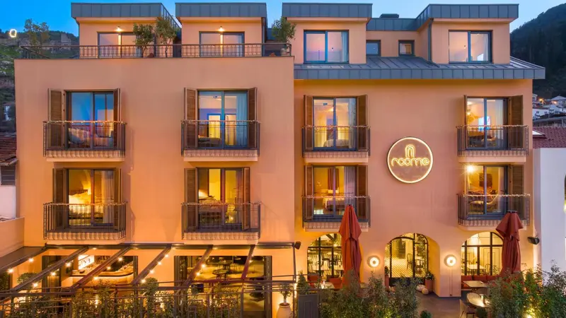Façade d'un bâtiment à plusieurs étages avec des balcons illuminés.