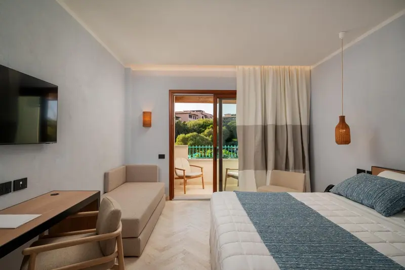 Une chambre lumineuse avec un lit et un accès à une terrasse.