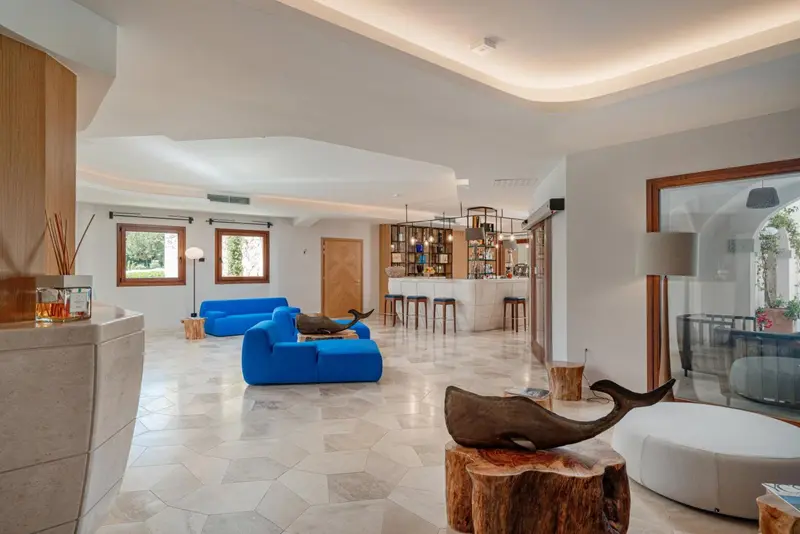 Espace de détente lumineux avec canapés bleus et décoration marine.