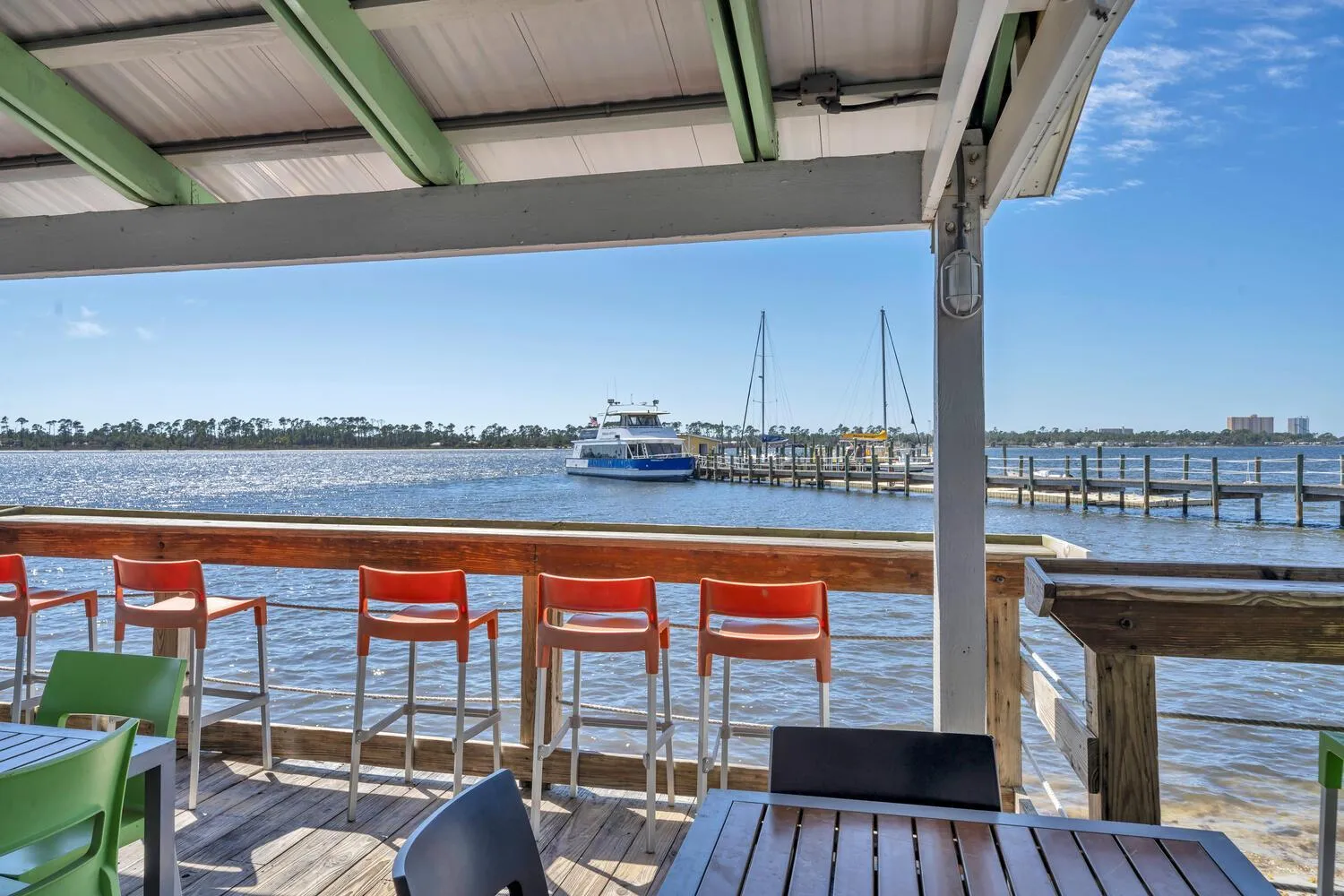 Terrasse avec des chaises et une vue sur la mer et un bateau.