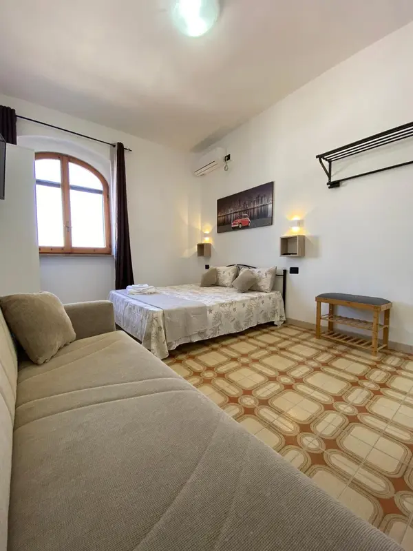 Une chambre lumineuse avec un canapé, un lit et un décor mural.