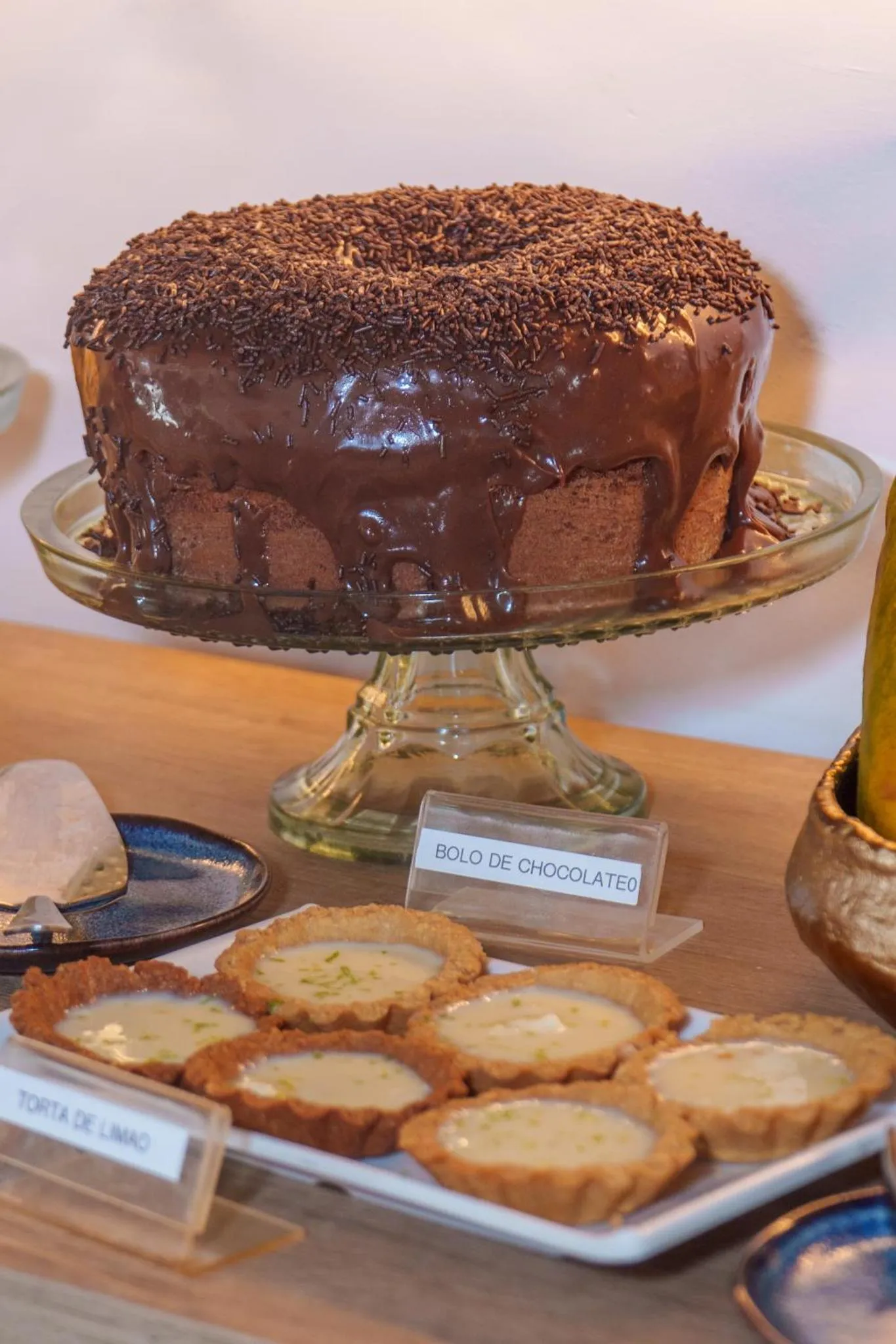 Une pâtisserie au chocolat est présentée sur un présentoir en verre.