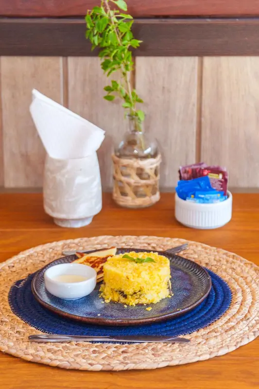 Assiette de riz et de poisson servi avec une sauce sur une table en terrasse.