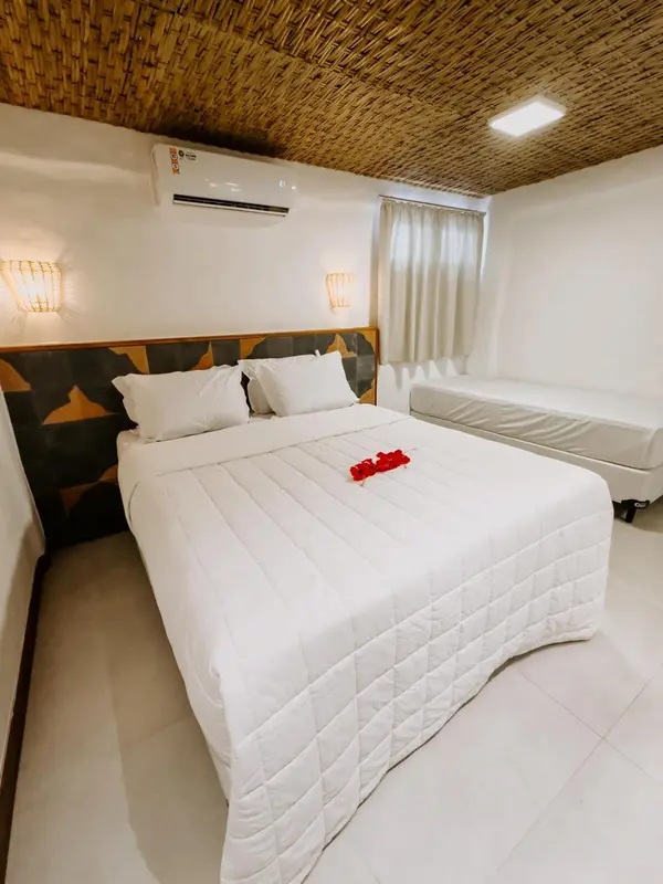 Une chambre lumineuse avec un lit double et une décoration florale.