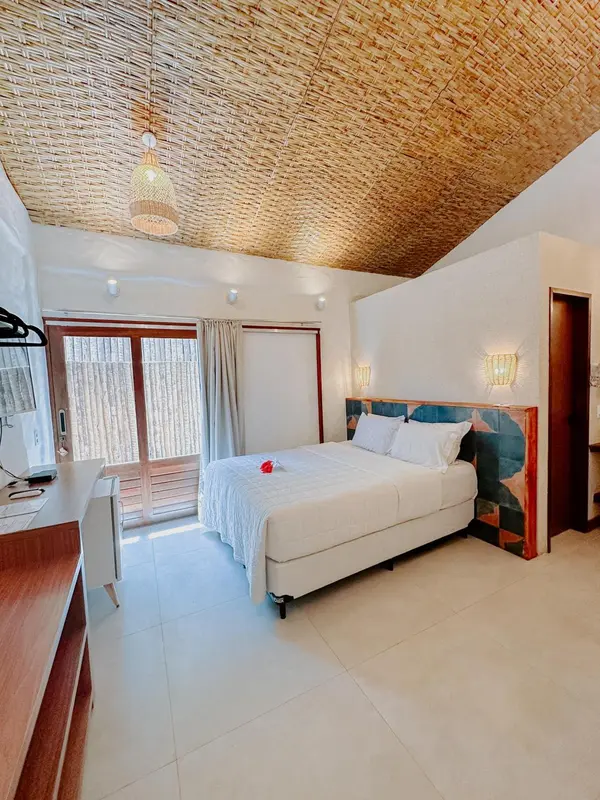 Une chambre lumineuse avec un lit recouvert d'une moustiquaire blanche.
