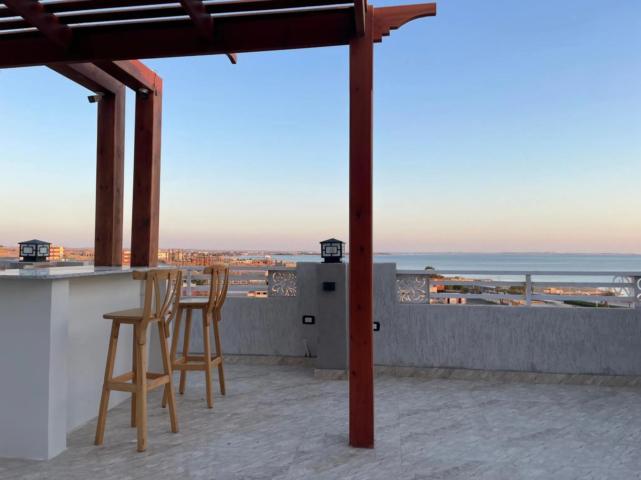 Terrasse avec bar et vue sur la mer au crépuscule.