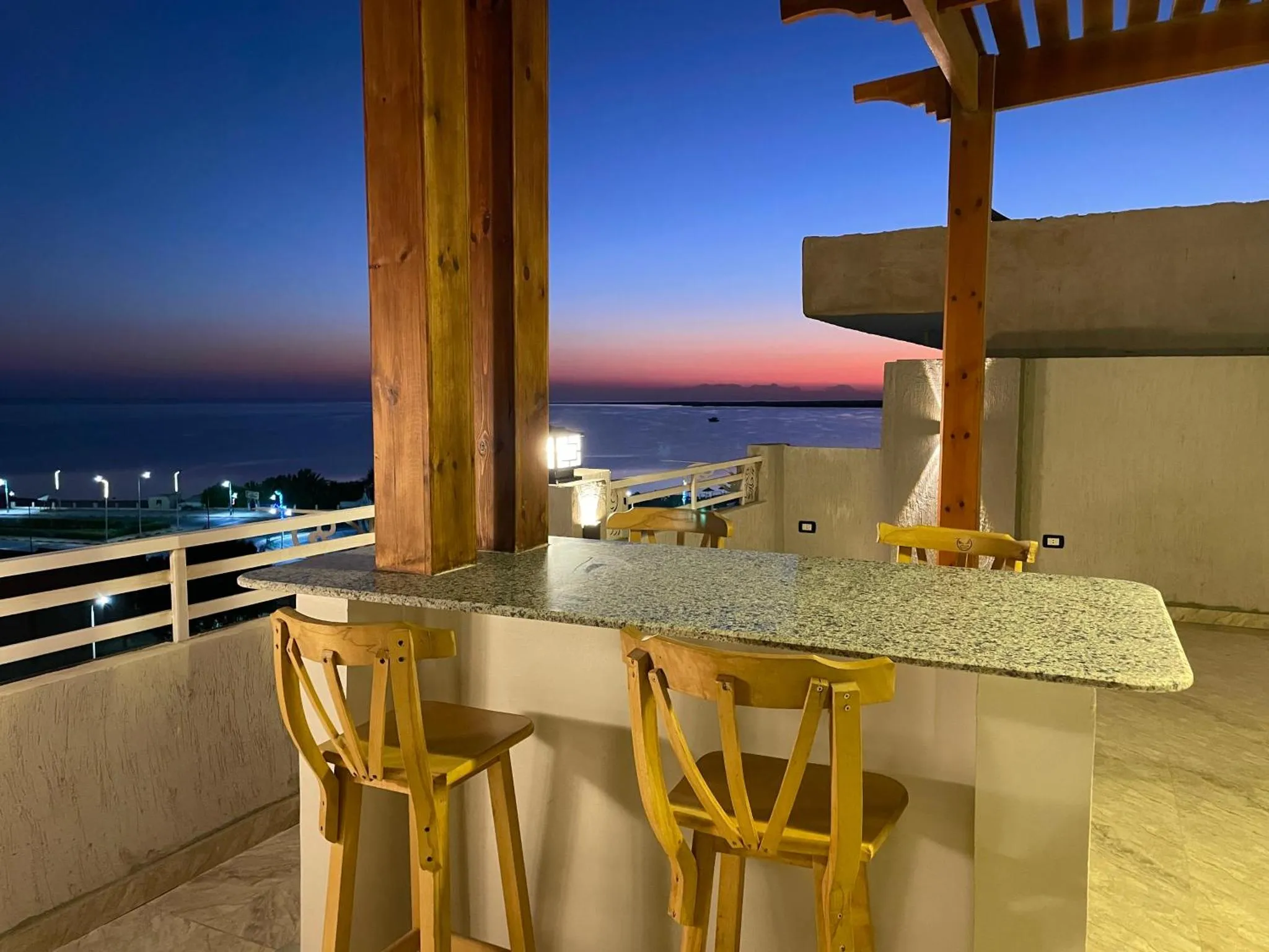 Terrasse avec comptoir et vue sur la mer au crépuscule.