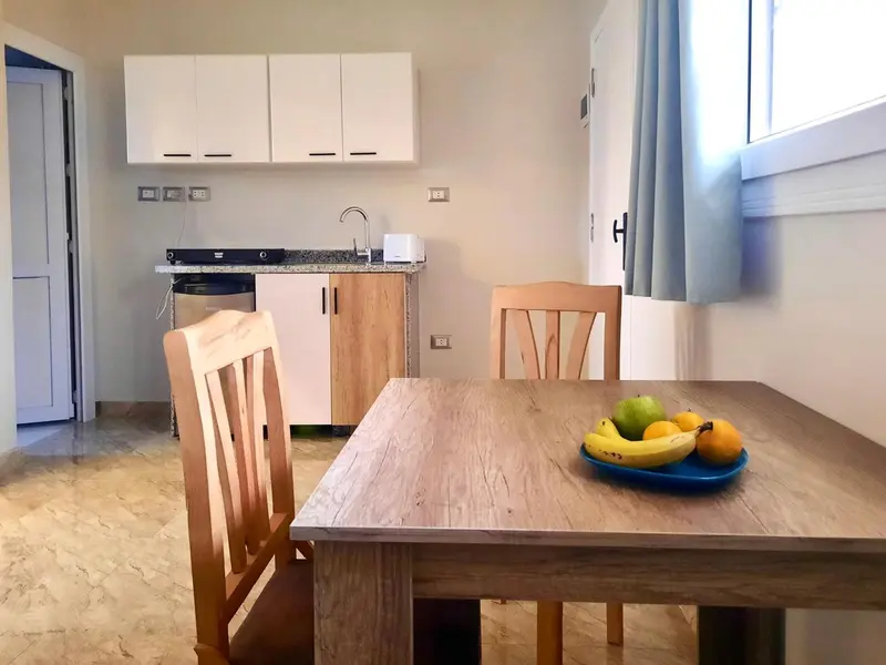 Une table en bois est mise en scène avec des fruits frais dans une pièce lumineuse.