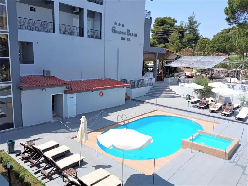Vue aérienne d'un hôtel avec piscine et transats.