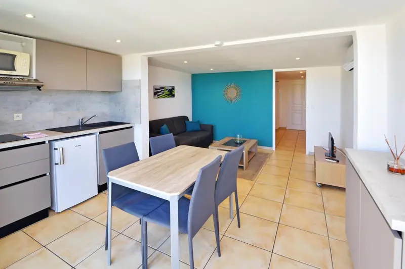 Une cuisine ouverte sur un espace salon avec table à manger.