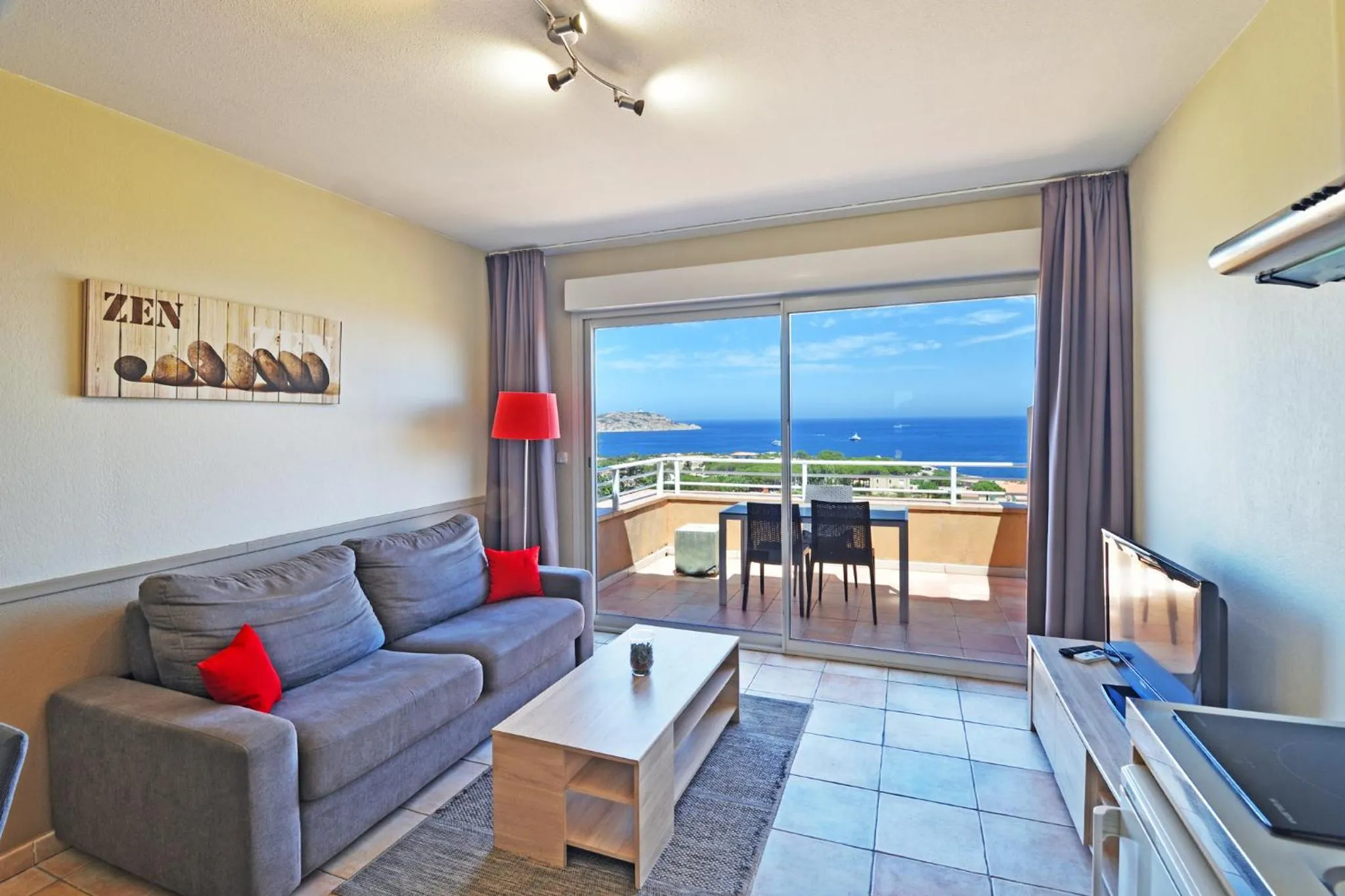Un salon lumineux s'ouvre sur une terrasse avec vue sur la mer.