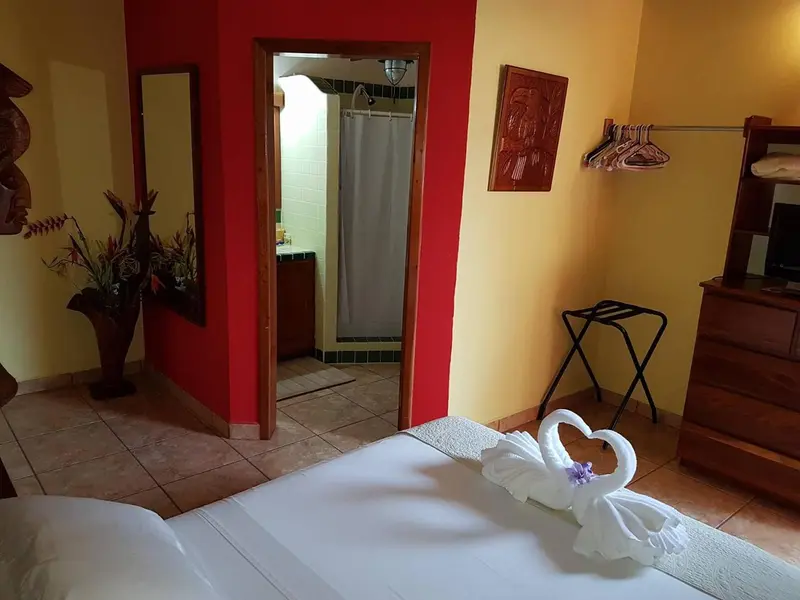 Une chambre lumineuse avec un lit décoré de serviettes en forme de cygnes.