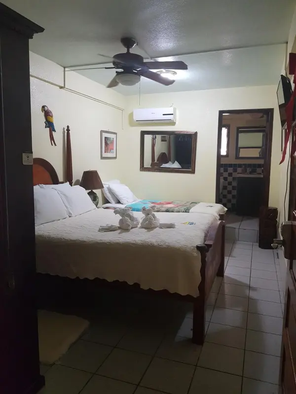 Une chambre lumineuse avec un grand lit recouvert d'une courtepointe.