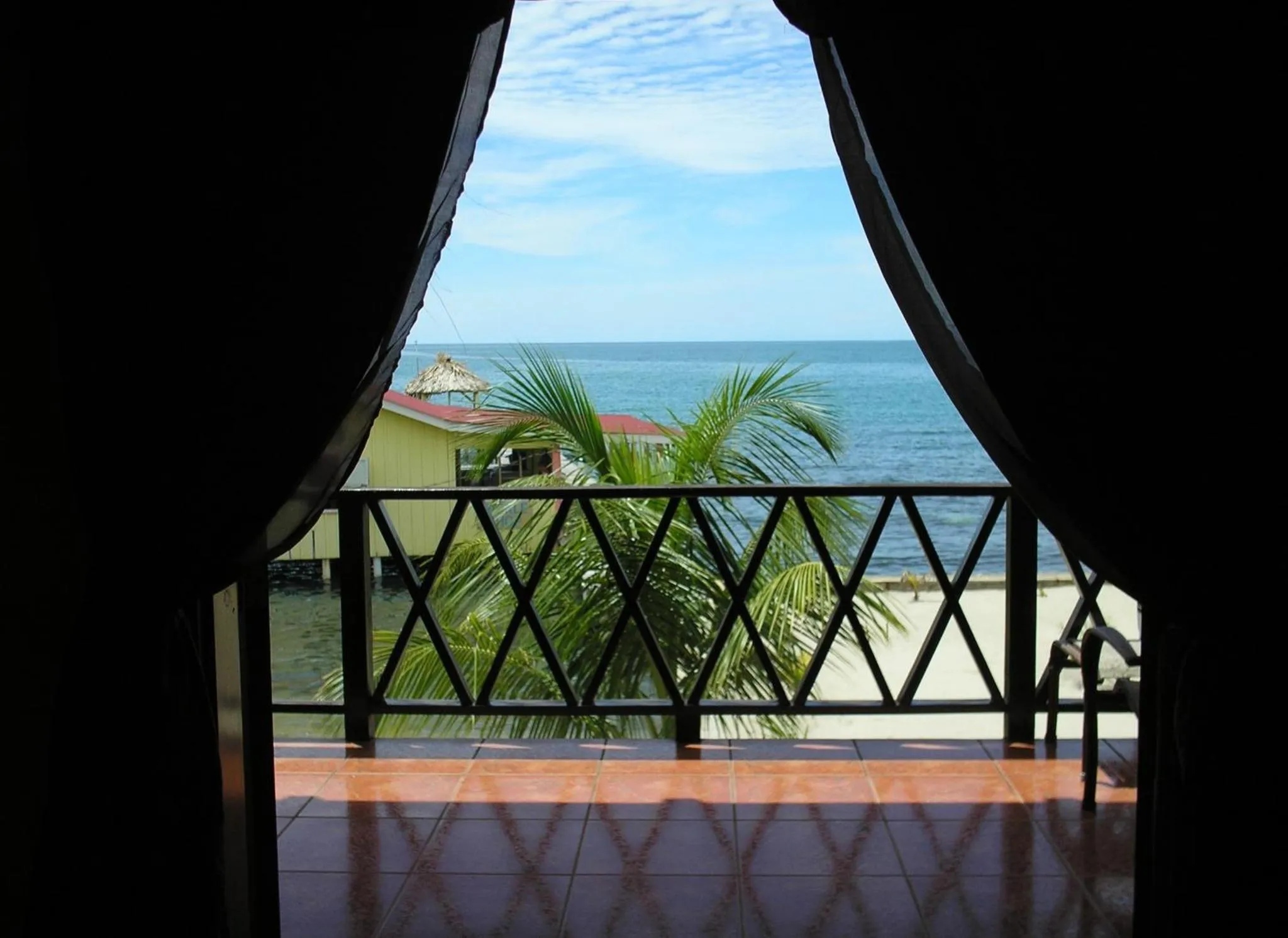 Vue sur la mer depuis une terrasse ombragée.