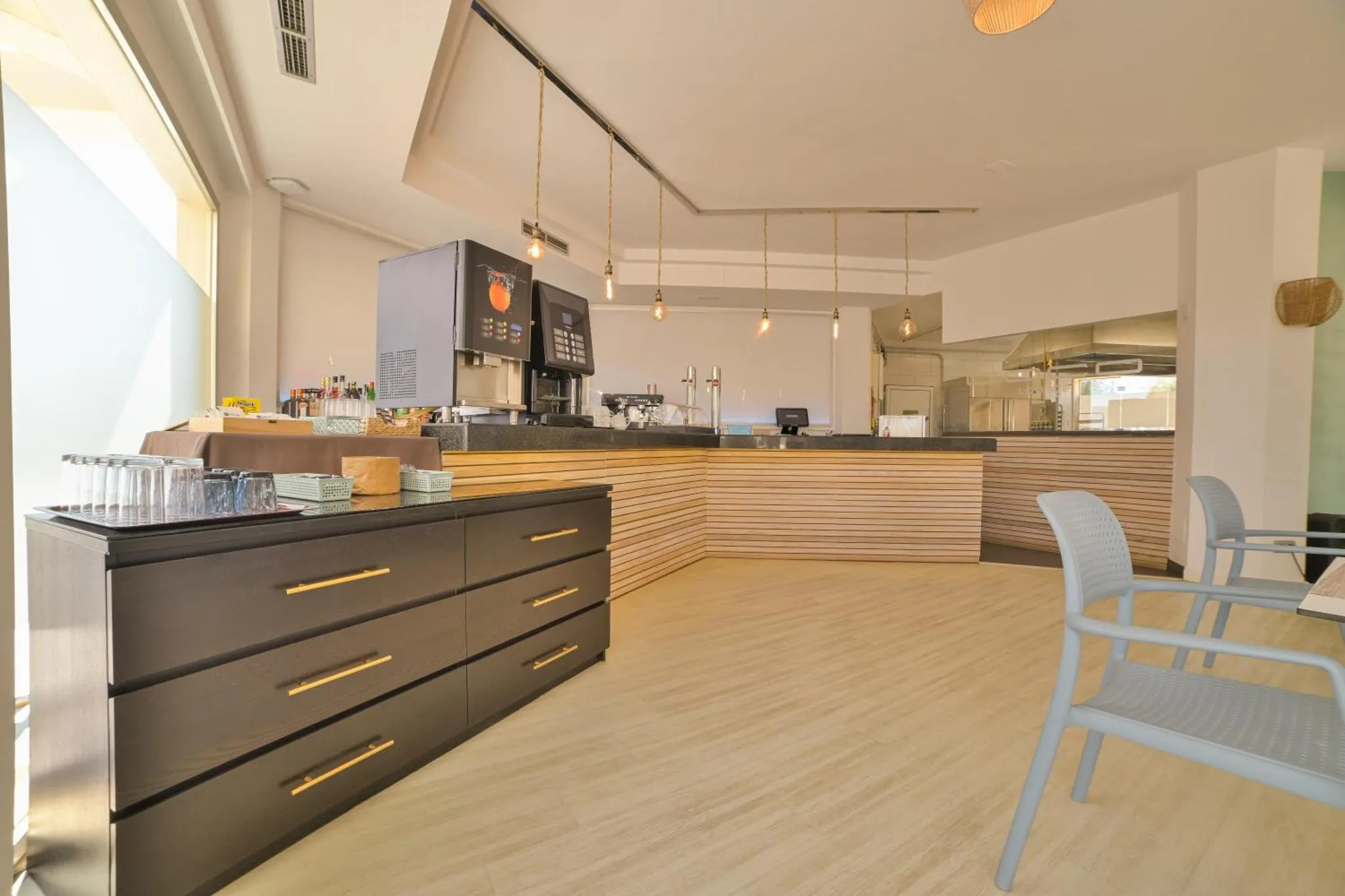 Un comptoir de buffet propose des boissons et des pâtisseries dans une salle lumineuse.