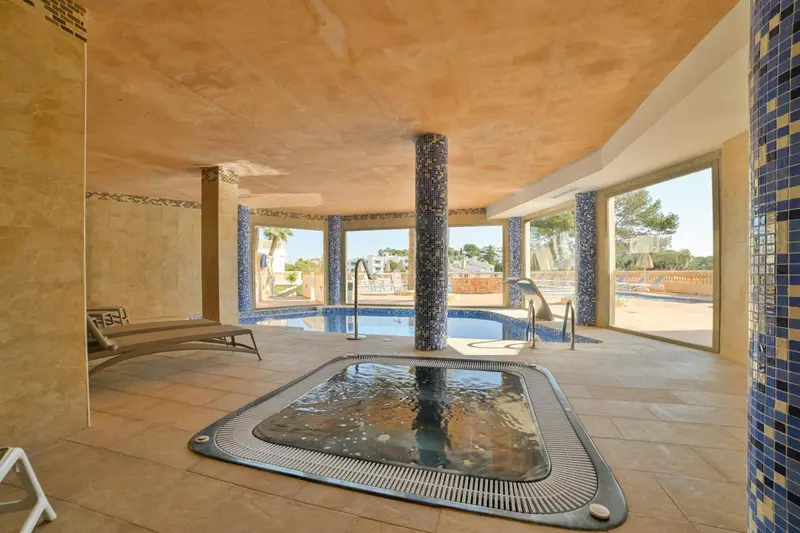 Espace de détente intérieur avec piscine et jacuzzi.