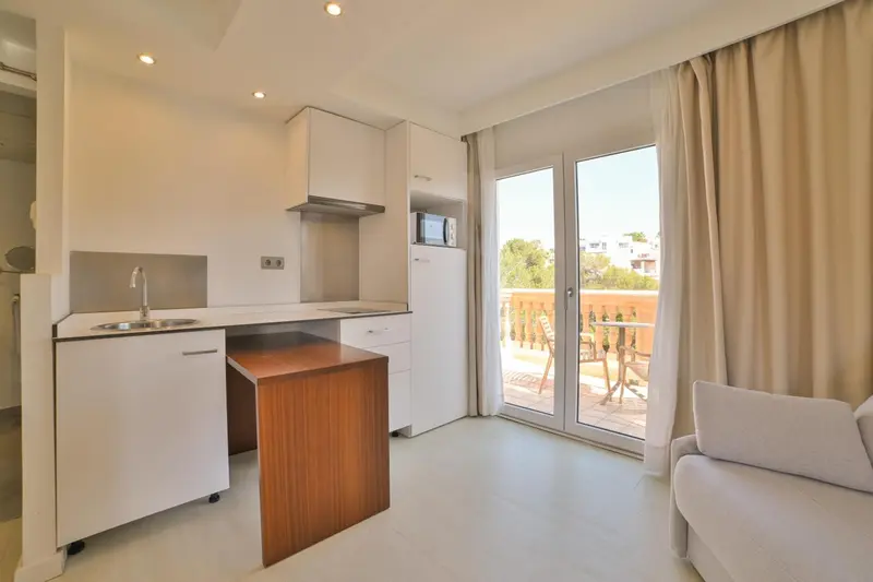 Une cuisine moderne s'ouvre sur une terrasse avec mobilier.