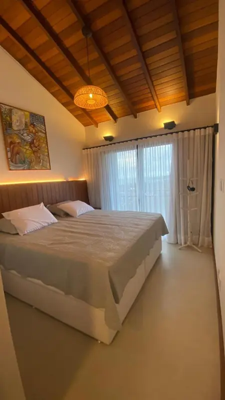 Une chambre lumineuse avec un lit double et un accès à une terrasse.