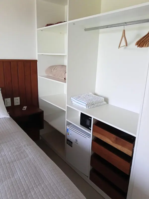 Une chambre avec un lit et un espace de rangement intégré.