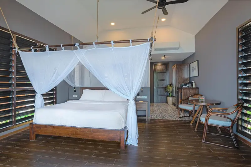 Une chambre avec un lit à baldaquin et un coin salon.