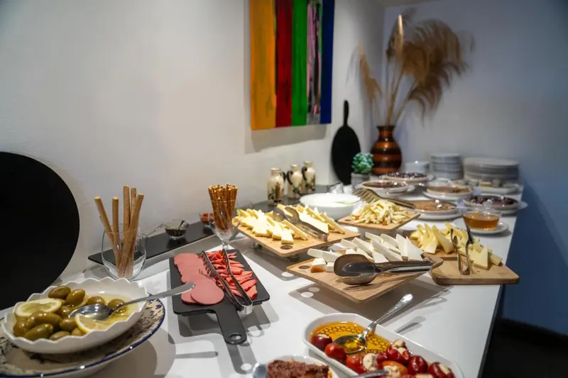 Une table garnie de divers plats et d'olives est présentée dans une pièce décorée.