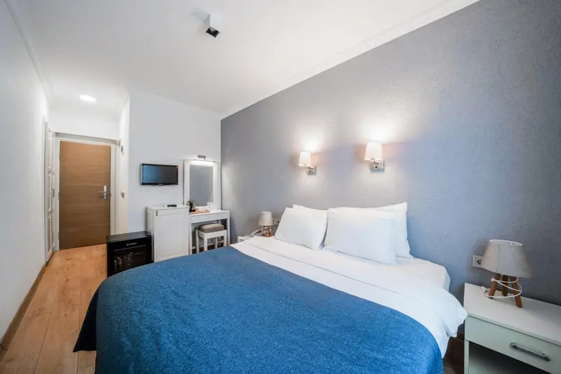 Une chambre lumineuse avec un lit double et un bureau.