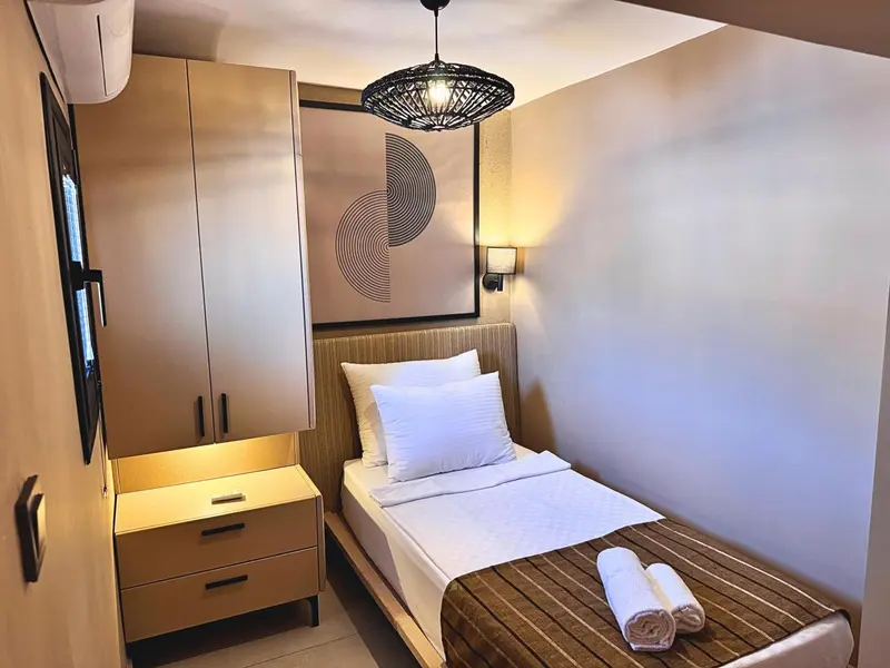 Une chambre simple avec un lit et des meubles en bois.