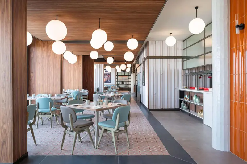 Une salle lumineuse avec des tables et des chaises pour les repas.