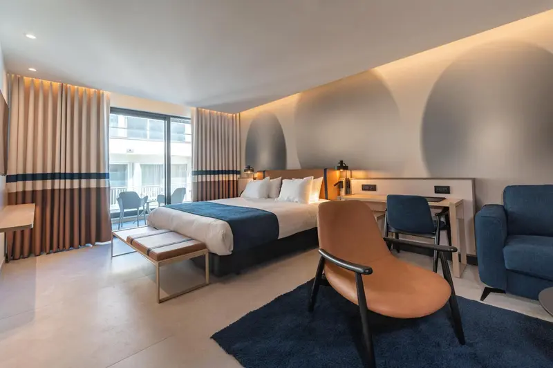 Une chambre moderne avec un grand lit et un coin salon.