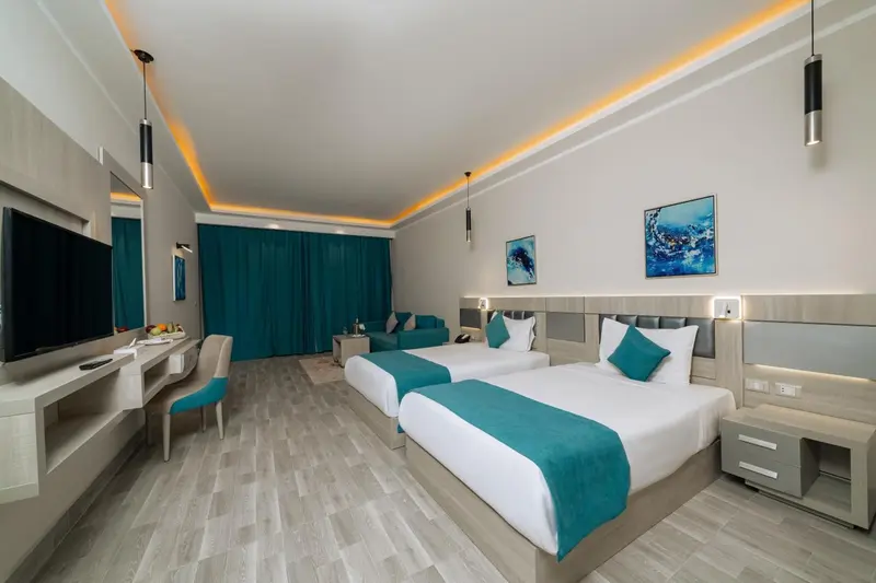 Chambre moderne avec deux lits simples et un coin salon.