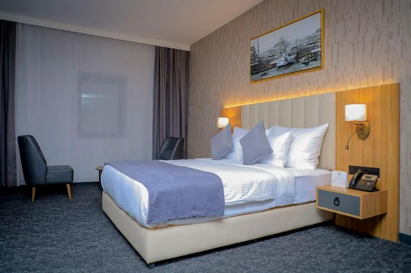 Une chambre moderne avec un grand lit et un fauteuil.