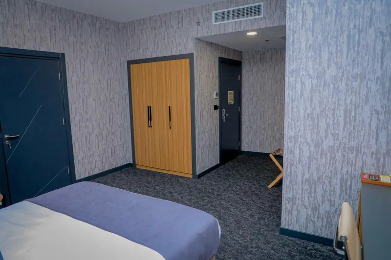 Une chambre d'hotel avec un lit et une armoire.