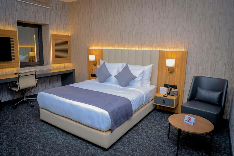 Chambre moderne avec un grand lit et un coin salon.