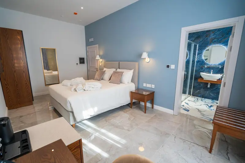 Une chambre lumineuse avec un grand lit et une salle de bain moderne.