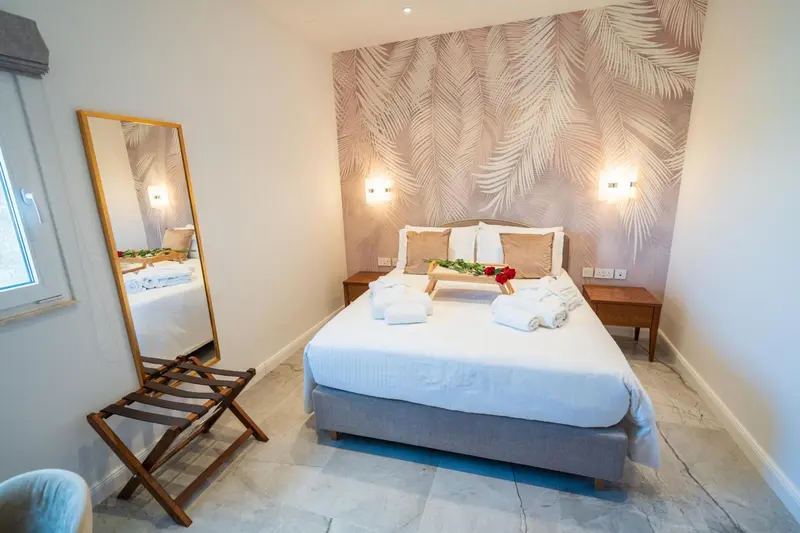 Une chambre lumineuse avec un grand lit et un miroir.
