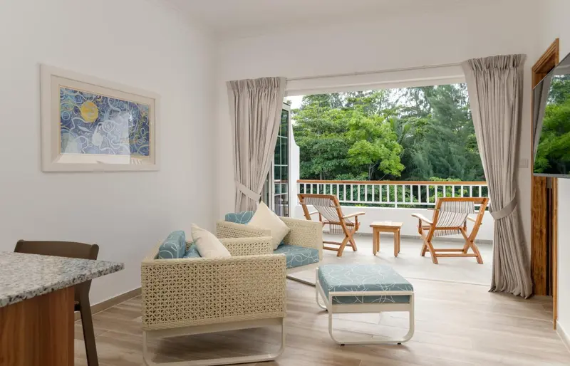 Un salon lumineux s'ouvre sur une terrasse avec mobilier d'extérieur.