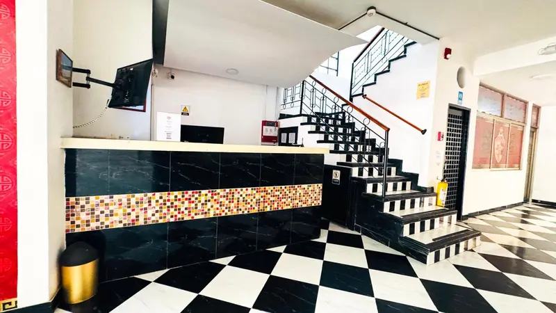 Hall d'entrée avec comptoir d'accueil et escalier.