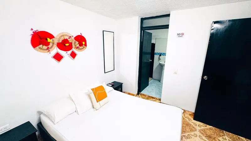 Une chambre lumineuse avec un lit simple et une décoration murale colorée.