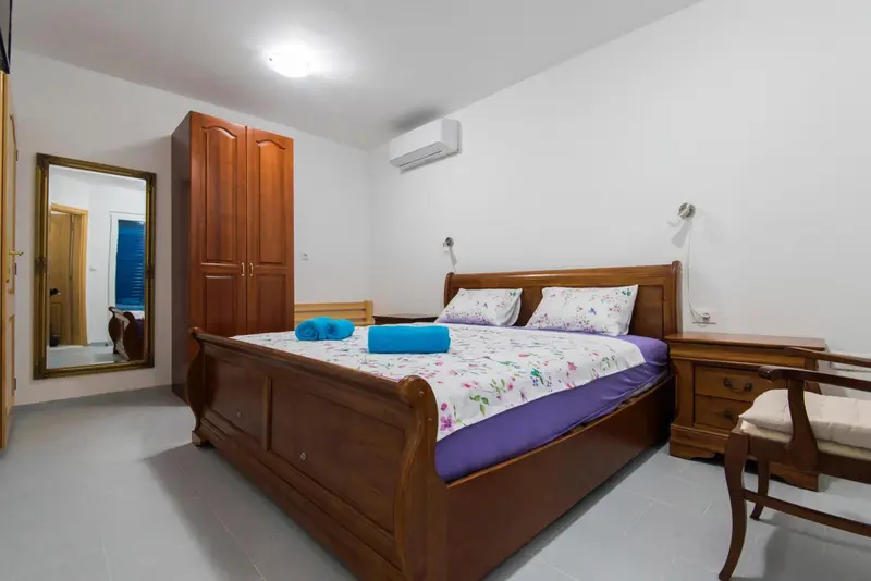 Une chambre lumineuse avec un grand lit et un meuble de rangement.