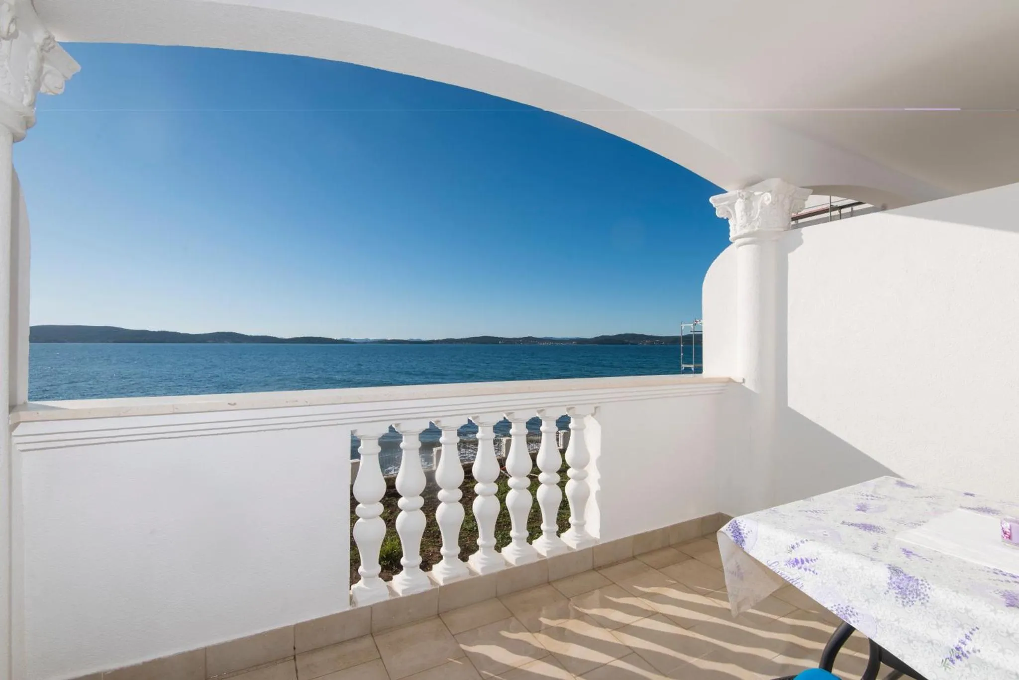 Vue sur la mer depuis une terrasse ensoleillée.