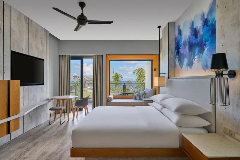 Une chambre lumineuse avec un grand lit et une vue sur la mer.