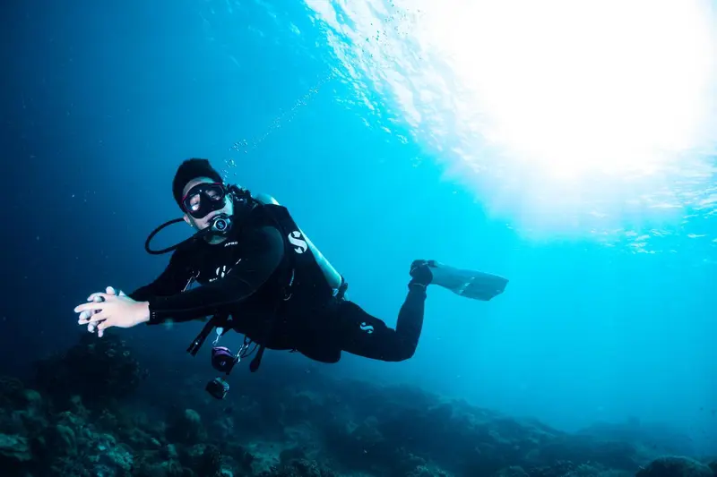 Un plongeur évolue dans un milieu aquatique bleu et lumineux.