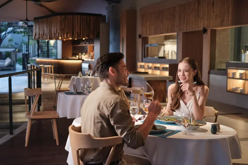 Un couple est attable dans un restaurant en soirée.